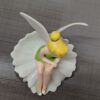 فیگور پری تینکربل دیزنی نشسته روی گل با لباس سبز و بال‌های سفید، مناسب برای کلکسیون و هدیه